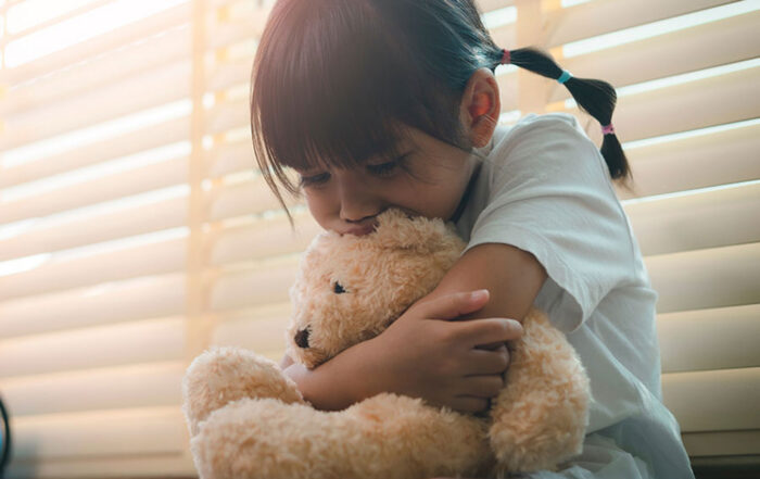 Sad child holding a teddy bear