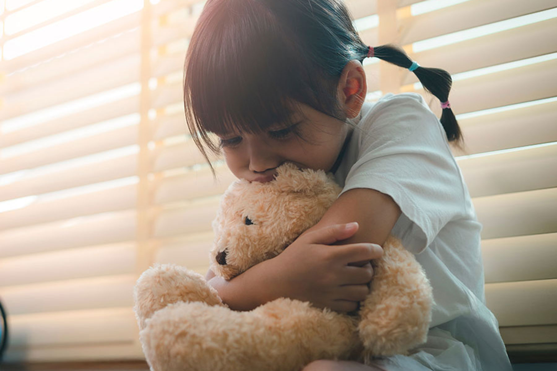 Sad child holding a teddy bear
